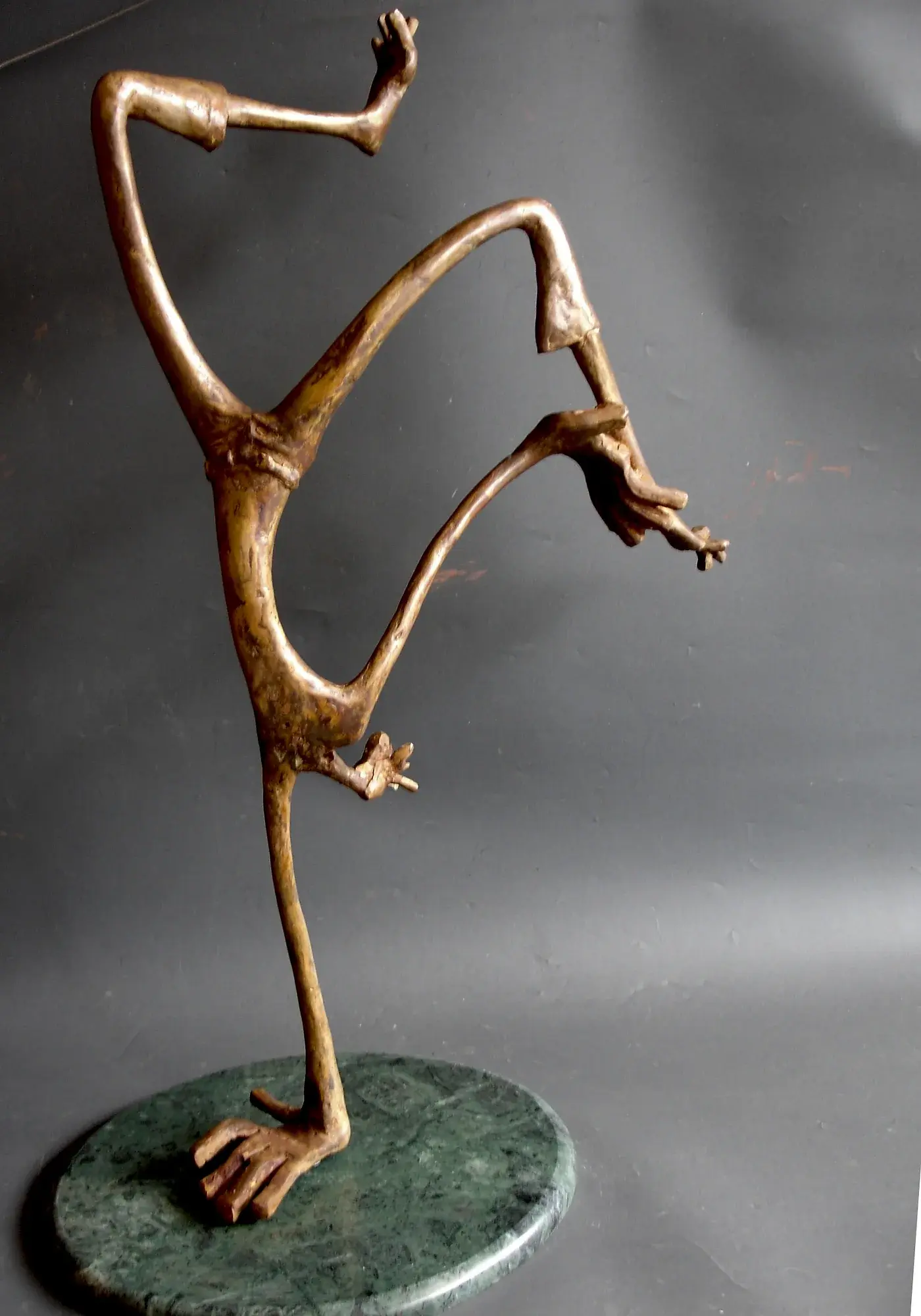 Bronze acrobatic figure captured mid-tumble in an abstract, dynamic pose